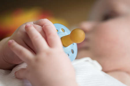 close-up view of hand of baby holding pacifier