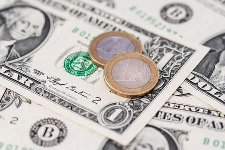 one Euro coins on US Dollar bills, parity and currency exchange rate conceptの写真素材
