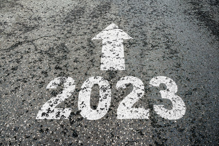 number 2023 and arrow pointing ahear on cracked asphalt, new year direction and expectation concept