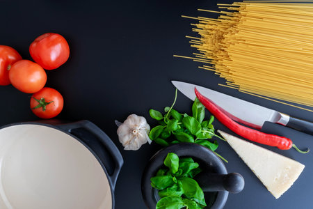 top down view of ingredients for italian pasta dish on dark stone tableの写真素材