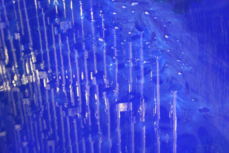 reflection of poles off a blue paint filled dipping tank