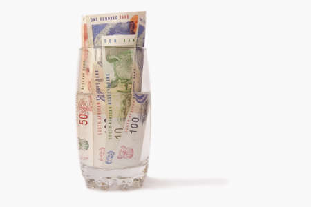 South African money in a glass of water isolated on a white backgroundの写真素材
