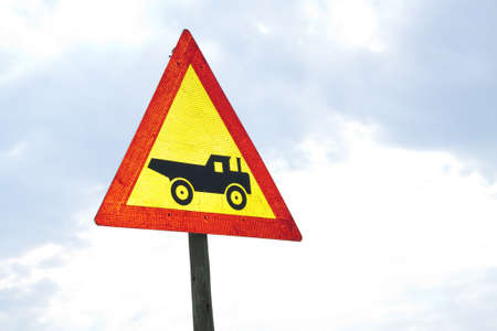 Warning road sign showing construction vehicle / truckの写真素材