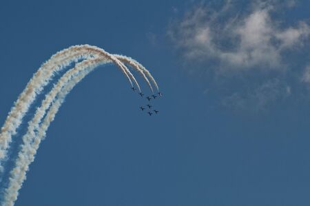 Aerobatics team create giant arch against blue skyの写真素材