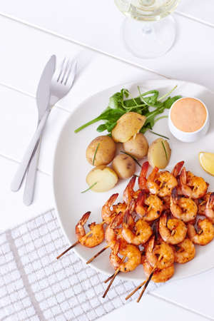 Seafood with potatoes on white plateの写真素材