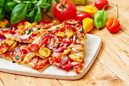 Chicken pizza with vegetables on wooden tableの写真素材