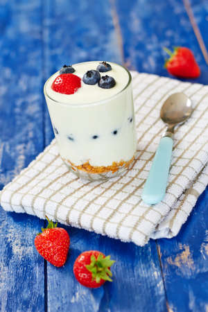 Cereals with yogurt and berries on white wooden tableの写真素材
