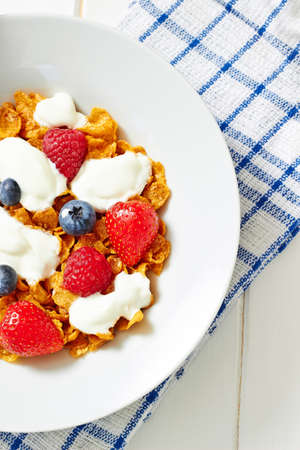 Cereals with yogurt and berries on wooden table, top view