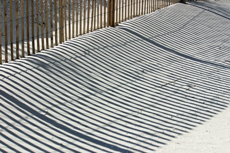 The shadow thrown by a fence on the beachの写真素材
