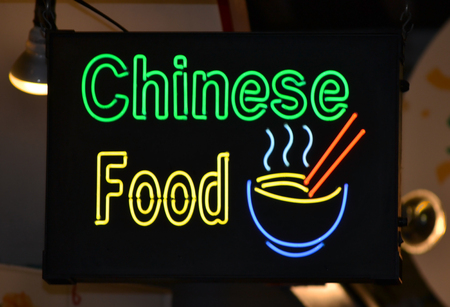 A green and yellow neon sign reading Chinese Foodの写真素材