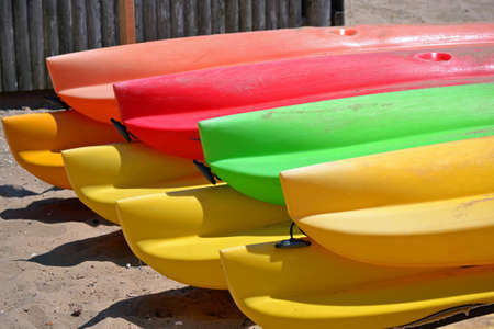 Two rows of colorful kayaks on the beachの写真素材