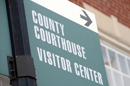 A green and white sign reading County Courthouse and Visitor Center