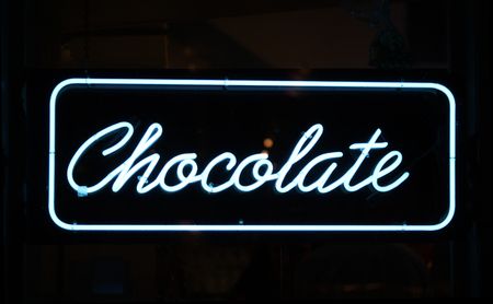 A neon sign reading Chocolate against a black background
