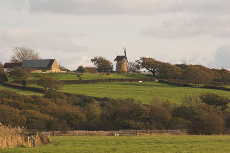Windmill in winter landscape on hillsideの写真素材