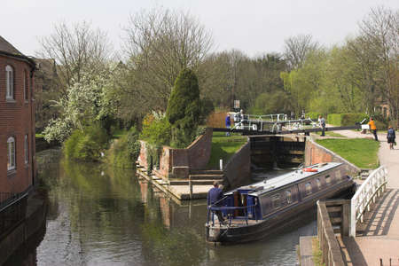 Blue narrow boat waiting to go through lock on canalの写真素材