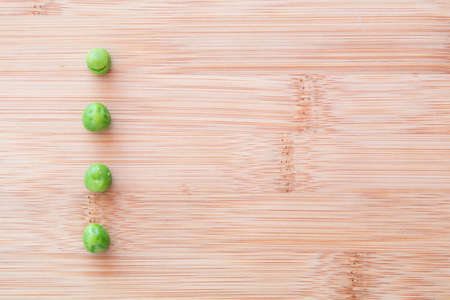 four peas representing the 4 p's of marketing presented on a wooden board like bullet points in a...