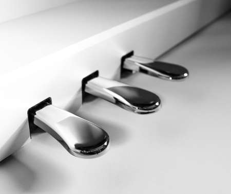 three piano pedals in silver that control the sound of the notesの写真素材