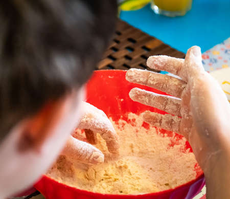 messy hands whilst mixing cake ingredients at home and bakingの写真素材