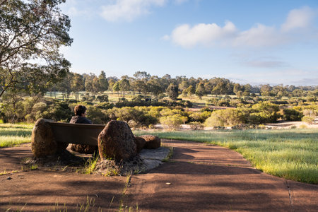 Lady sitting on seat enjoying view at Joshua Lake Park, Western Australiaの写真素材