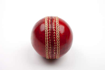 A Close-up shot of a red Cricket ball on white background.の写真素材