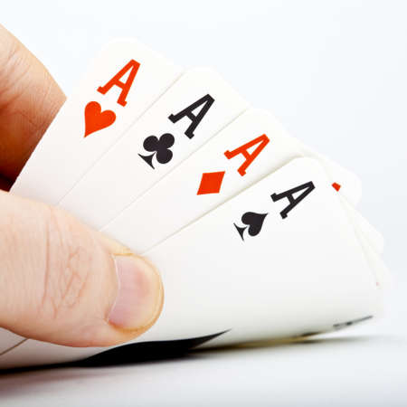 Hand and Four Aces over a white background の写真素材