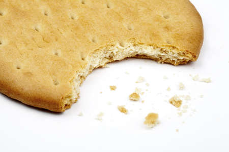 Half-eaten biscuit over a white background.の写真素材