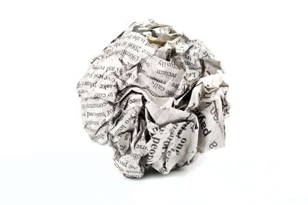 A screwed up piece of newspaper over a white background.の写真素材