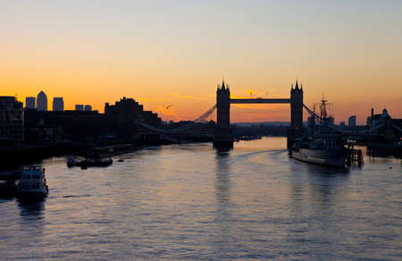 The beautiful sunrise behind Tower Bridge in London   HMS Belfast and the skyscrapers in Docklands...