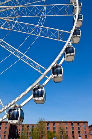 The magnificent Ferris Wheel of Liverpool   The buildings of Albert Dock can be seen in the distance のeditorial素材