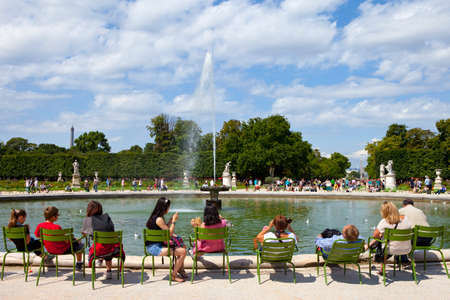 PARIS, FRANCE - AUGUST 4TH 2014: People relaxing around a fountain in the beautiful Jardin des Tuileries in Paris on the 4th August 2014.  The Eiffel Tower, Place de la Concorde and the Arc de Triomphe can be seen in the distance.のeditorial素材