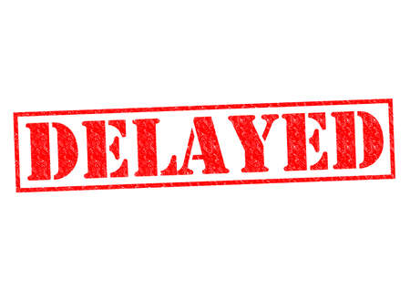DELAYED red Rubber Stamp over a white background.の写真素材