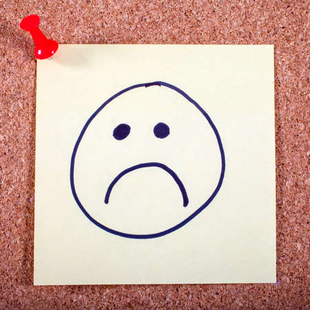 An unhappy face on a piece of Memo Paper.の写真素材