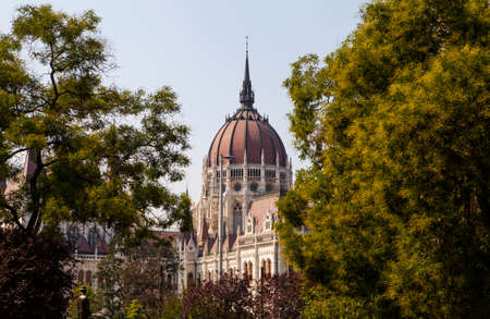 The beautiful architecture of the Hungarian Parliament Building viewed through the trees in Budapest, Hungary.の写真素材