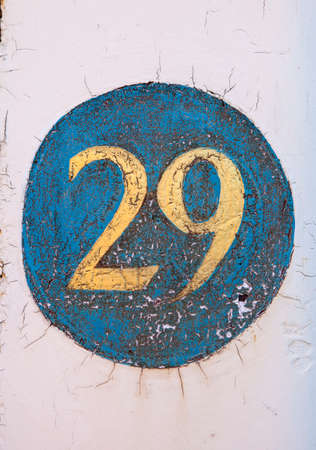 Number 29 painted on a textured wall.