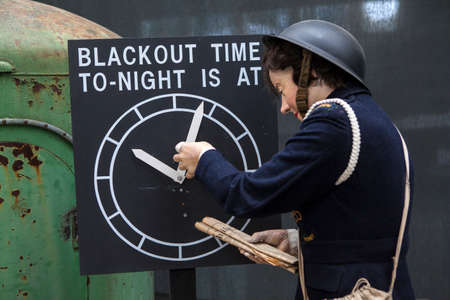 CAMBRIDGESHIRE, UK - OCTOBER 5TH 2015: An Air-raid Warden mannequin adjusting the blackout time at...