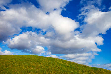 Lush green hilltop with a beautiful cloudscape.