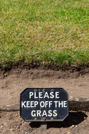 A polite sign warning people to Keep off of the Grass.の写真素材