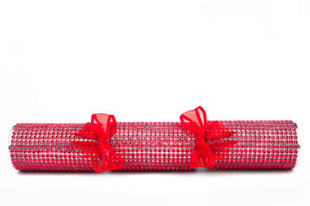 A studio shot of a Crackers or otherwise known as a Bon Bon.  A traditional cracker consists of a cardboard tube wrapped in a brightly decorated twist of paper with a gift in the central chamber.の写真素材