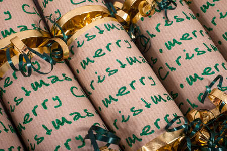 A studio shot of Christmas Crackers or otherwise known as Bon Bons.  A traditional cracker consists of a cardboard tube wrapped in a brightly decorated twist of paper with a gift in the central chamber.の写真素材