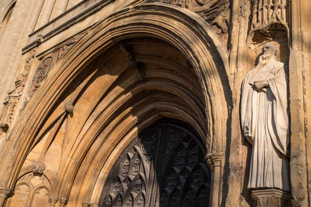 A sculpture of St. Benedict on the exterior of the West Porch of Norwich Cathedral in the historic city of Norwich, UK.のeditorial素材