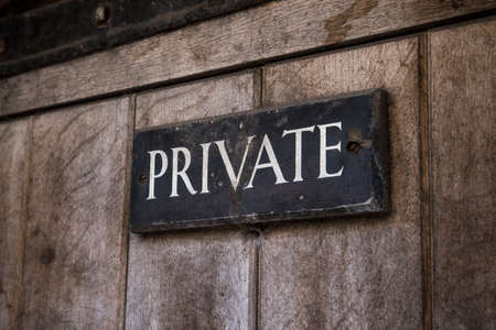 A close-up of a Private sign on an old wooden door.の写真素材