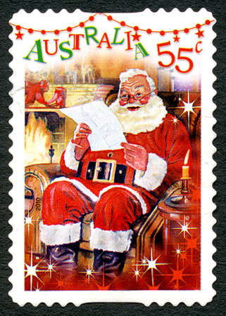 AUSTRALIA - CIRCA 2010: A used postage stamp from Australia, depicting a festive scene of Santa Claus reading a letter by the fireplace, circa 2010.のeditorial素材