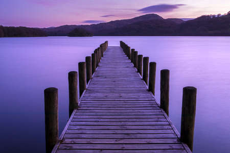 An evening view of a jetty on Coniston Water in the Lake District in Cumbria, UK.の写真素材