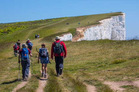 EAST SUSSEX, UK - MAY 25TH 2017: Hikers walking along the white chalk cliffs at Beachy Head in East Sussex, UK, on 25th May 2017.のeditorial素材