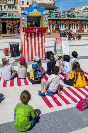 BRIGHTON, UK - MAY 31ST 2017: A group of children watching a traditional Punch and Judy puppet show on the seafront in Brighton, UK, on 31st May 2017.のeditorial素材
