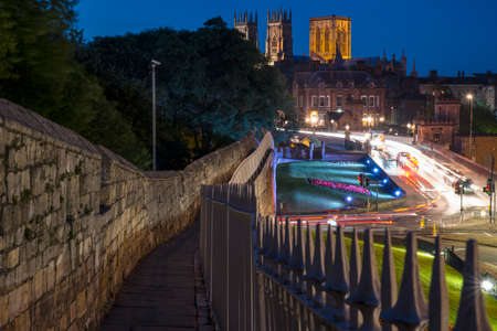 A beautiful evening view of the city walls and the illuminated York Minster, in the historic city of...
