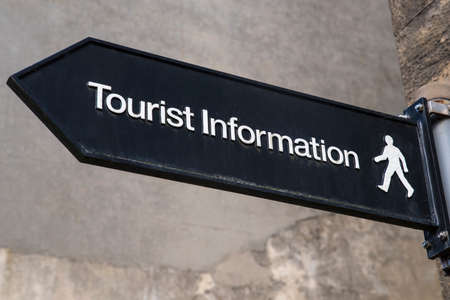 A sign showing the direction to a tourist information.の写真素材