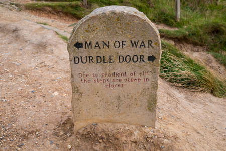 A marker on the South West Coast Path showing directions to Durdle Door and Man of War in Dorset, UK.の写真素材