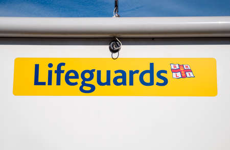 SWANAGE, UK - AUGUST 16TH 2017: A Lifeguard sign on a kiosk on Swanage seafront in Dorset, UK, on 16th August 2017.のeditorial素材