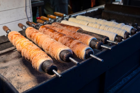 Trdelnik being cooked in Prague, Czech Republic. Trdelnik is a kind of spit cake, also known as Chimney Cake and is often served with choc.の写真素材